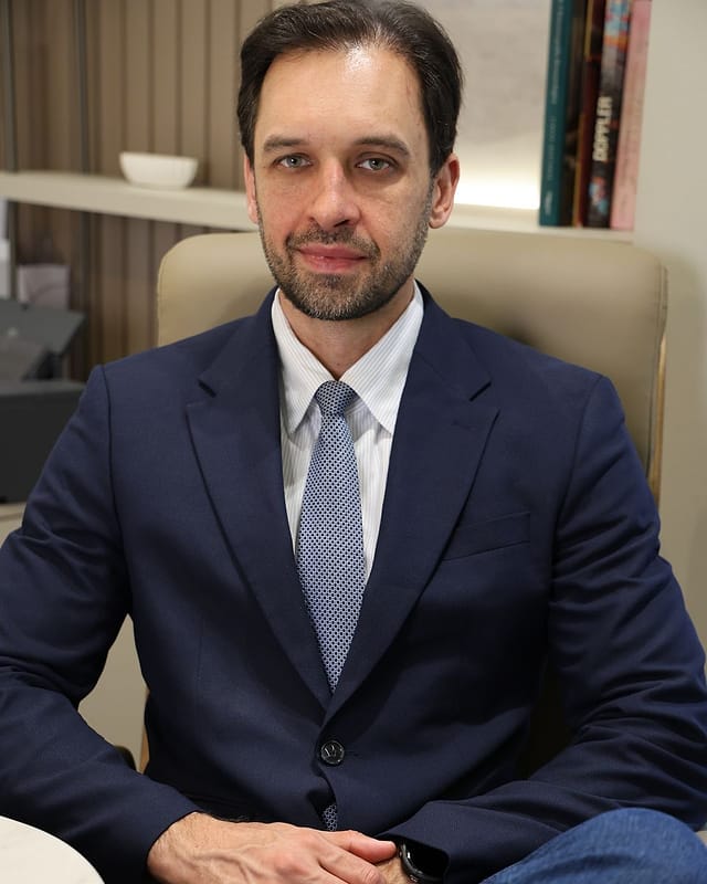 Dr. Bruno Bereza sentado em poltrona no consultório
